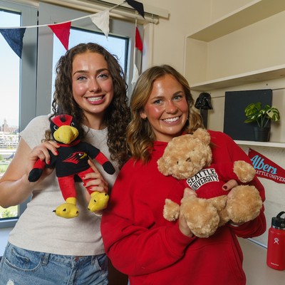 2 students holding stuffed animals in a resident room