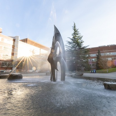 Fountain and sculpture on the Seattle University campus illuminated by the morning sun.