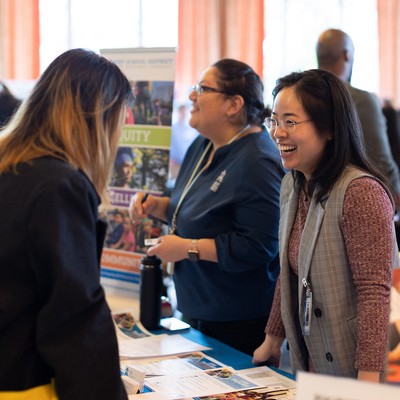 Photo of an employer and student talking at a campus event