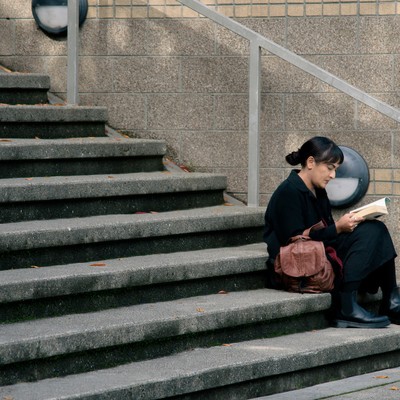 A student reading on campus outside on a set of stairs