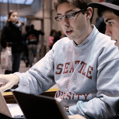 A couple of men looking at a laptop.