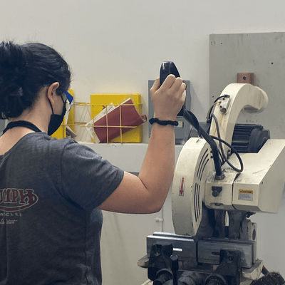 female student using chopsaw in machine shop