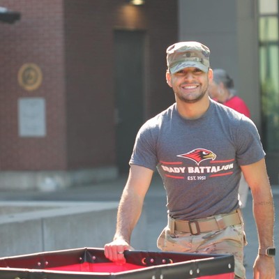 Cadet helping new students move to campus