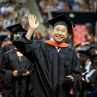 A graduate waving during the commencement ceremony
