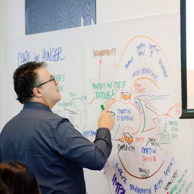 Albers student drawing a diagram on a whiteboard