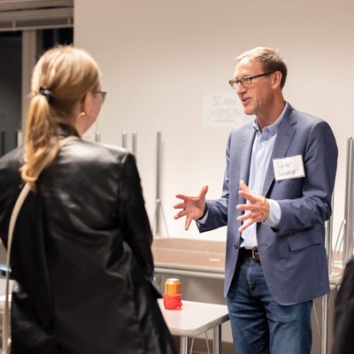 A group of professionals engaged in a conversation during a networking event.