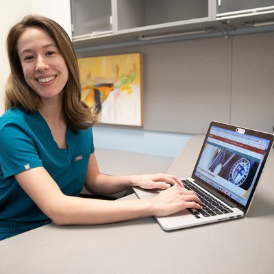 A woman sitting at a desk with a laptop computer.