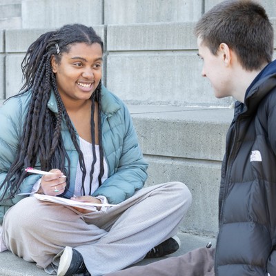 smiling student with pen and notebook