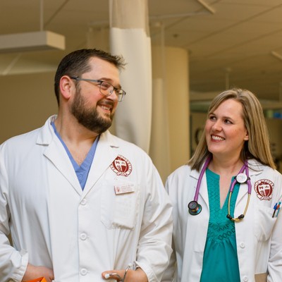 A man and woman wearing white lab coats.