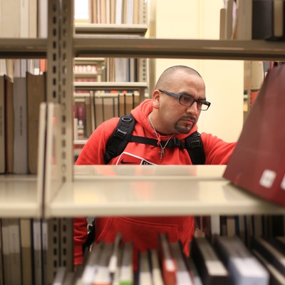 A man looking at books in a library.