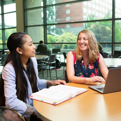 A group of students sitting around a table in a library.