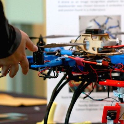A person is looking at a drone on a table.