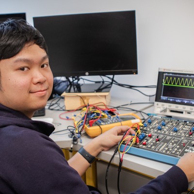 A man sitting at a desk with electronic equipment.