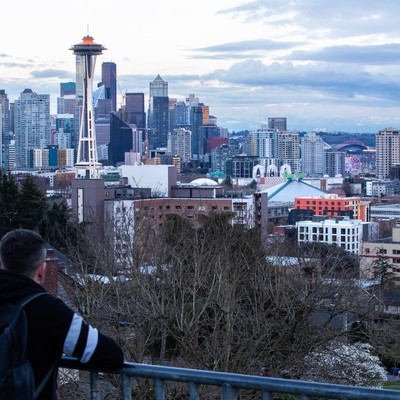 A man looking at the seattle skyline from a railing.