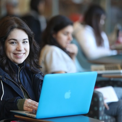 A woman sitting at a table with a laptop.