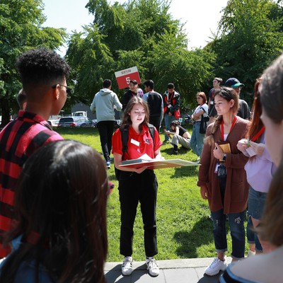 A group of people standing around in a park.