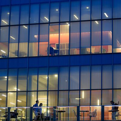 A pattern of lights shine through the glass facade of Lemieux Library