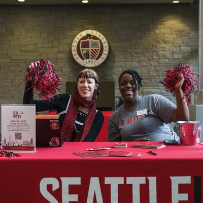 two people tabling with red pom-poms