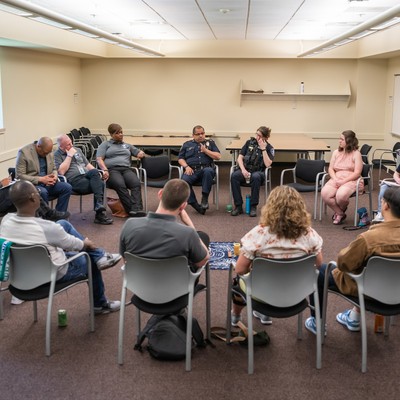 People sitting in a circle of chairs