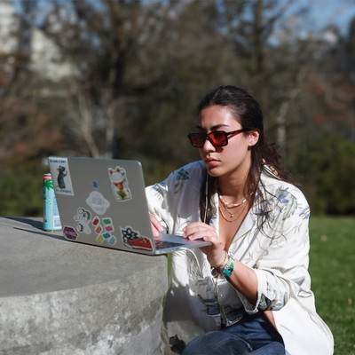 A student in sunglasses reading something on her laptop
