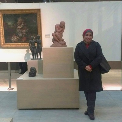 a woman in a museum next to a sculpture