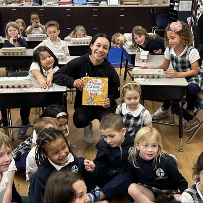 an SU student sharing a storybook with a classroom full of elementary school kids