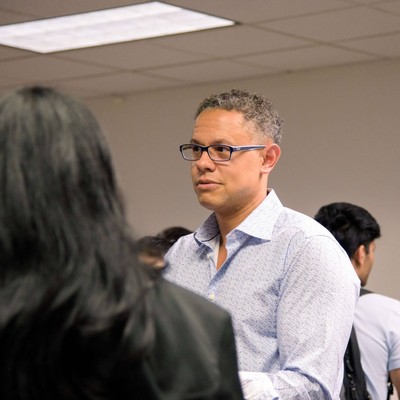 Man in a blue shirt engaged in a conversation with a student