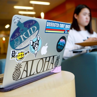 A student laptop with various stickers.