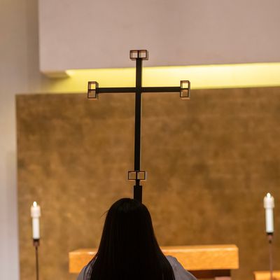 Girl holding large cross, back to camera