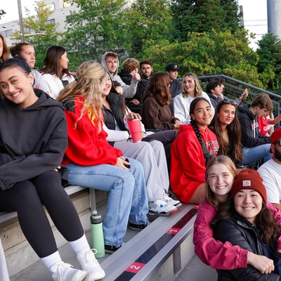 A group of people sitting on bleachers at a football game.