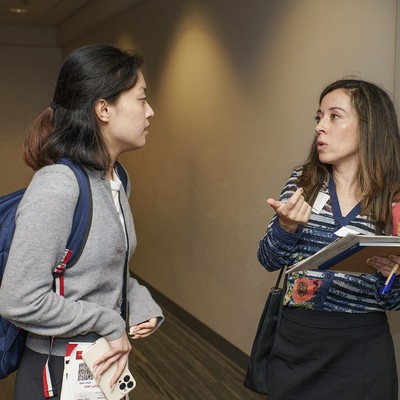 Two women speaking in a hallway