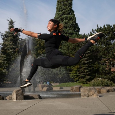 A dancer leaping into the air in front of the fountain