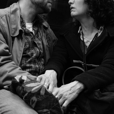 two people holding hands on a train
