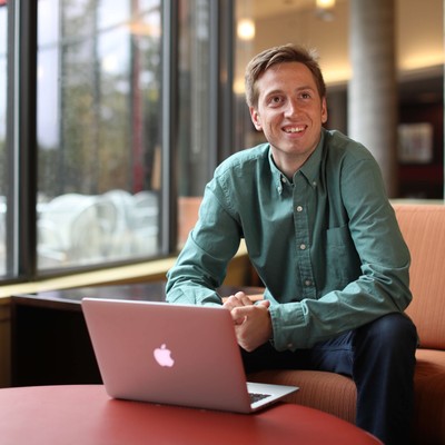 A man sitting on a couch with a laptop.