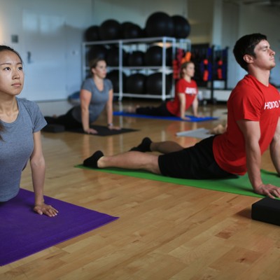 A group of people doing yoga in a gym.