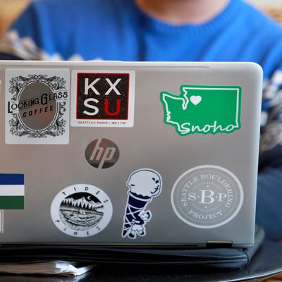 A student has a computer in front of him with colorful stickers