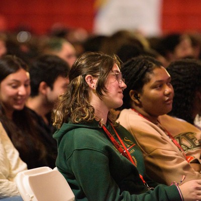 students sitting in an auditorium listening to a new student orientation
