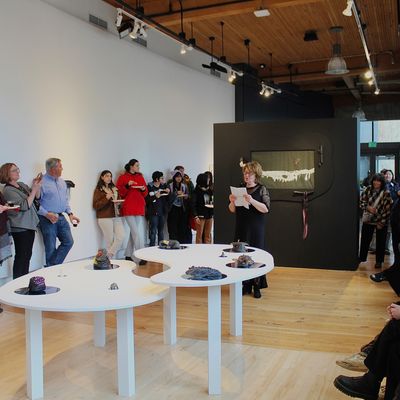 An artist talks about their work in the gallery