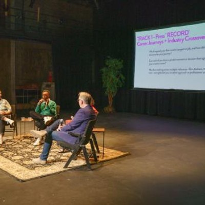 Panelists sit onstage, giving a lecture for Seattle Creates.