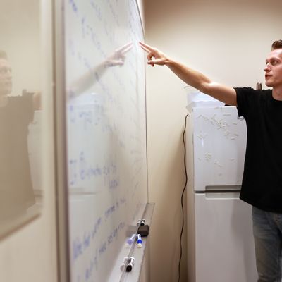 Student works on equation in engineering building