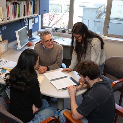 Students sitting around desk with faculty member