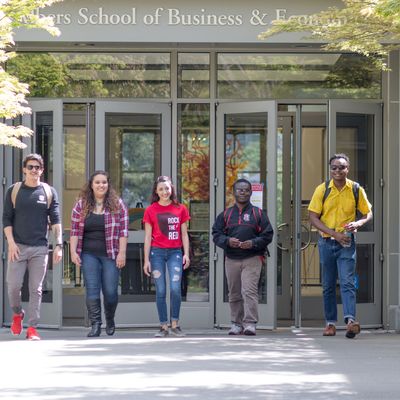Group of students exiting a school of business and economics building.