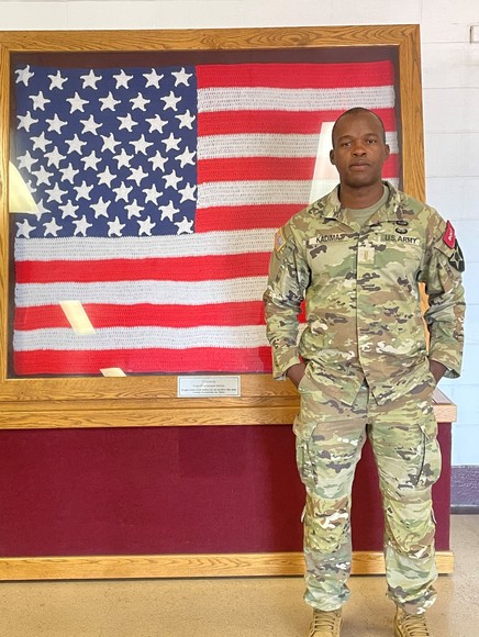 Second lieutenant Stephane Kadima in front of American Flag