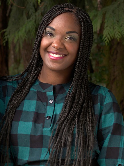 Woman smiling in front of green foliage