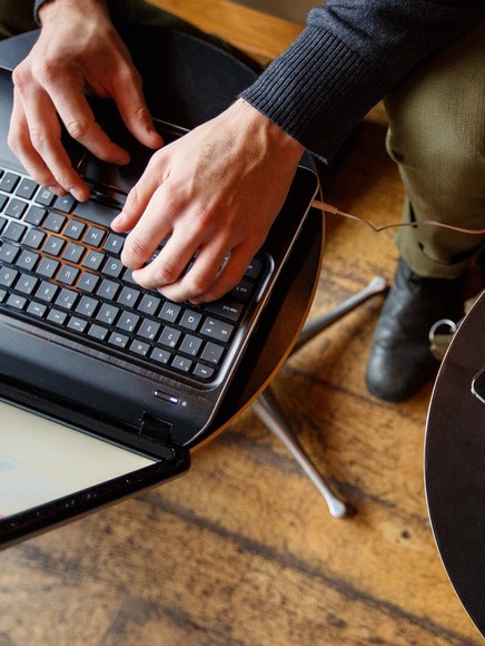 A closeup on the hands of a student using a laptop