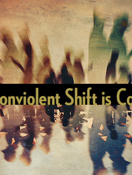 Blurry photo of people walking. On the middle a black strip with yellow letters that read: The Nonviolent Shift is Coming