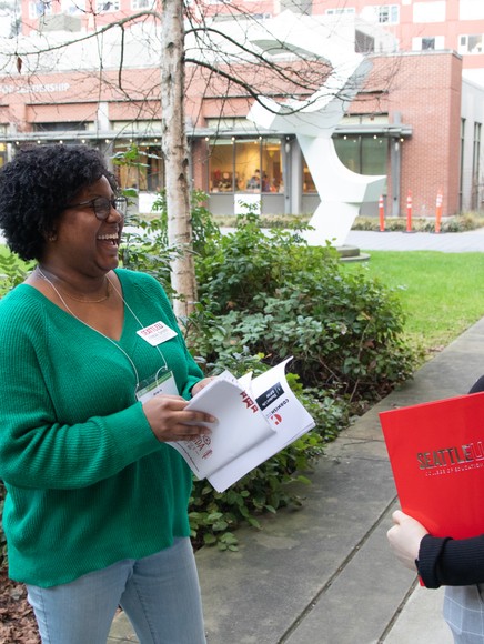 Two SDA students laugh on sidewalk outside Student Center