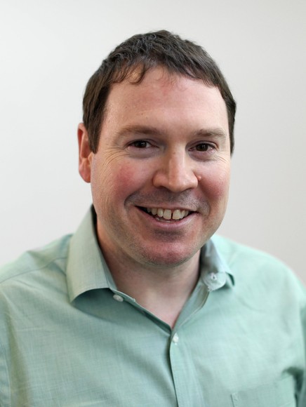 John Luethe in front of white background smiling