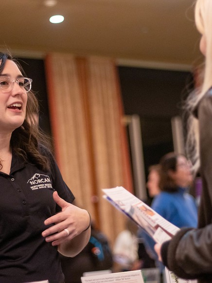 Two women talk at an event