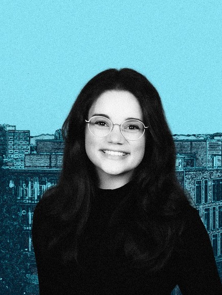 Elyse Vincent headshot smiling in front of blue backdrop